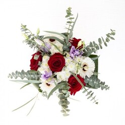 From a florist's perspective in Tolworth, this bouquet is a balanced showcase of classic refinement and contemporary artistry. Creamy gerberas radiate from their rich brown centers, establishing an anchor of brightness within the arrangement. Spiraling alongside are bold red roses-each bloom deeply saturated and symbolic of lasting affection, familiar on St. George's Road gatherings and family milestones. Ethereal sprays of eucalyptus rise above, their cool, silvery tones and invigorating scent adding texture and life to the bouquet. Interspersed are lilac-tinted lisianthus, offering both a whimsical note and variation, like a spring breeze drifting through Fishponds Park at sunset. Cloud-soft filler flowers add gentle volume, echoing the calm and generous spirit of the Tolworth community. Broad, verdant leaves elegantly cradle the bouquet, while the water-filled glass vase below reflects the fresh promise of each stem. Thoughtfully arranged by Flowers Tolworth, this arrangement is ideal for anniversaries, housewarmings, or thoughtful gifts, each element carefully chosen to speak to the beauty and friendliness Tolworth is known for.
