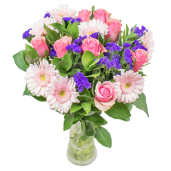 As an experienced Tolworth florist, I find particular inspiration in the interplay between the pastel gerberas and classic pink roses within this bouquet. The pinks meld together in watercolor-like washes-subtle, luminous, and comforting-much like the peaceful mornings along Ewell Road. Punctuating the bouquet are sprigs of deep purple statice, offering a satisfying contrast that enlivens every view. The leaves below, lush and dewy, anchor the swirling blooms and evoke garden freshness found on walks through Fishponds Park. Set in a simple yet refined glass vase, the floral colors glow softly in natural light, creating an inviting and warm atmosphere perfect for a get-well gesture or a stylish accent in a Tolworth living room. Every flower in this arrangement tells of careful craftsmanship and an honest joy-a piece created to uplift, brighten, and embody the welcoming spirit of Tolworth itself.